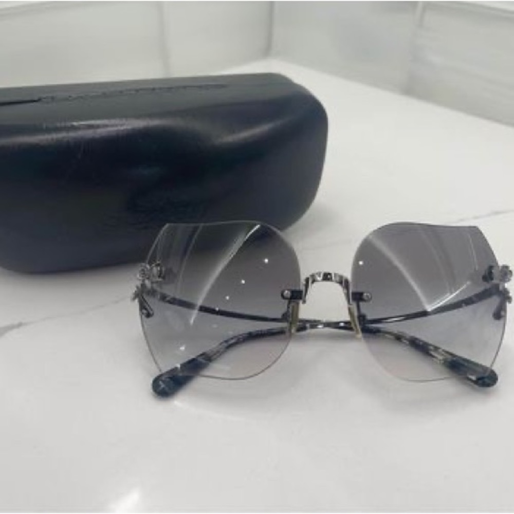 Coach women’s sunglasses with light blue lenses and silver roses on lense